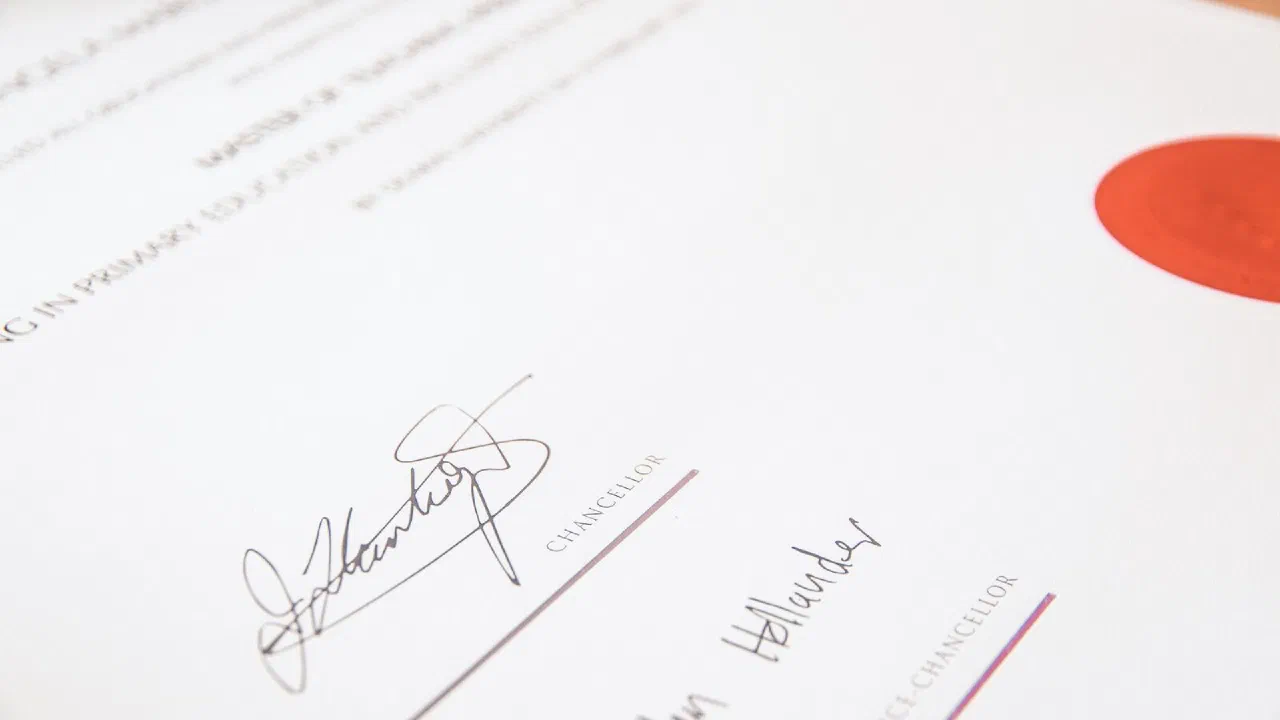 A printed certificate carrying a red seal and two handwritten signatures